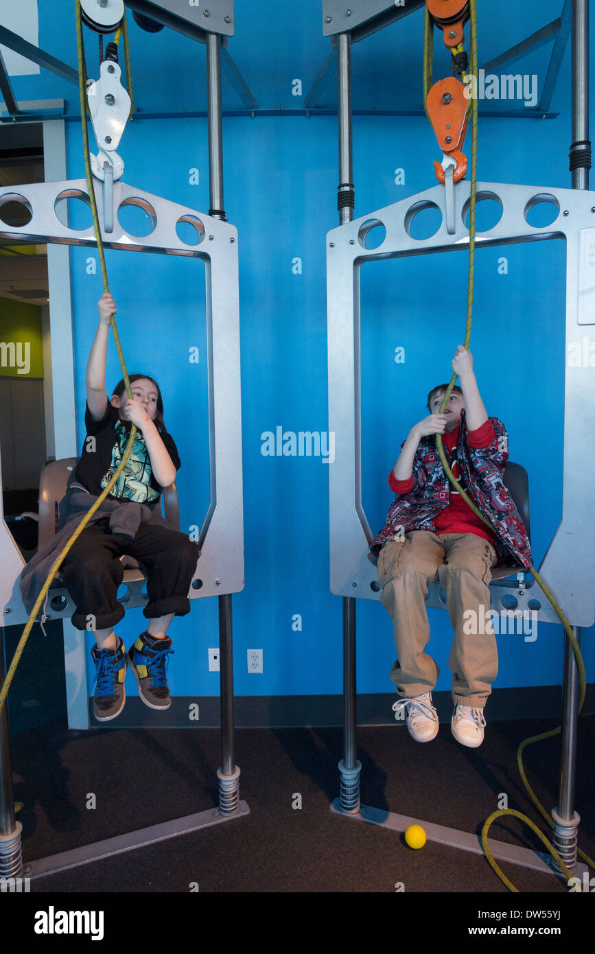Boys interacting with pulley display at Telus, World of Science, Vancouver, British Columbia, Canada Stock Photo