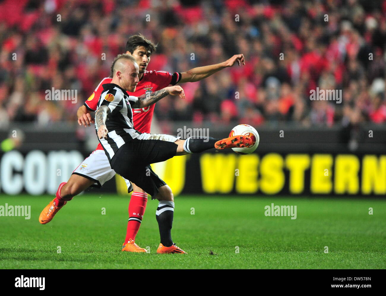 Lisbon, Portugal. 27th Feb, 2014. Andre Gomes (Back) of Benfica fights for the ball during the UEFA Europa League round of 32 second-leg football match between Benfica and PAOK Thessaloniki of Greece at the Luz stadium in Lisbon, capital of Portugal, on Feb. 27, 2014. Benfica defeated PAOK 3-0 to go through 4-0 on aggregate. Credit:  Zhang Liyun/Xinhua/Alamy Live News Stock Photo