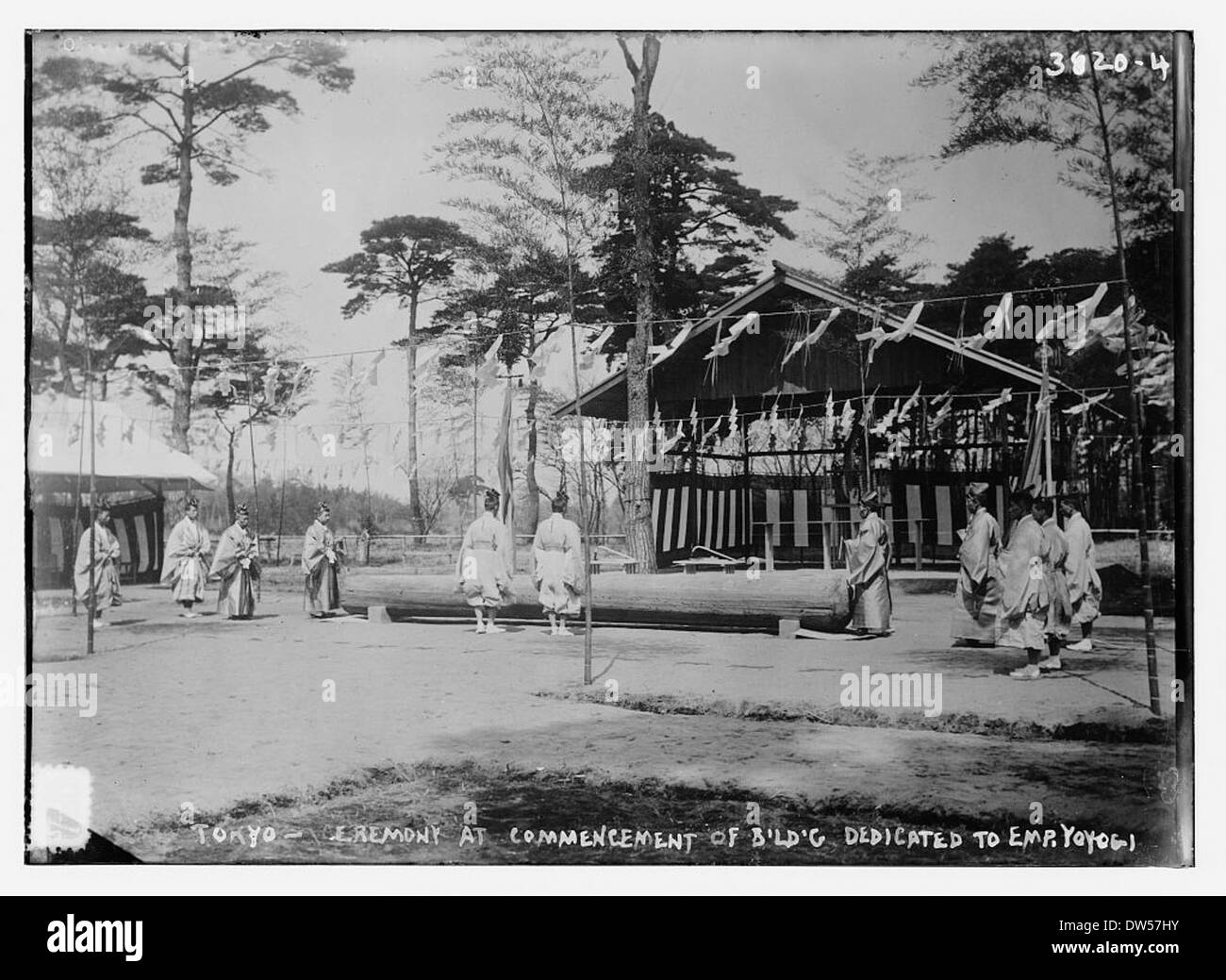 A ceremony marking the commencement of a building dedicated to Emperor Yoyogi in Tokyo is captured in this vintage photograph. The event reflects the cultural and historical significance of the dedication. Stock Photo