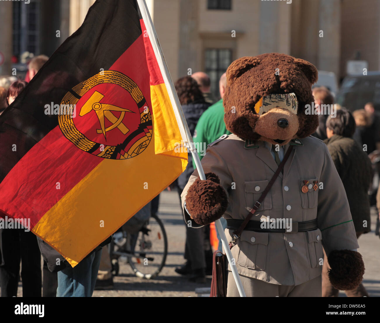 A Man dressed up as Berli bear waits for tourists with an East German flag at the Brandenburg Gate in Berlin, October, 03, 2013. More and more tourists come Berlin. The photo is part of a series on tourism in Berlin. Photo. Wolfram Steinberg dpa Stock Photo