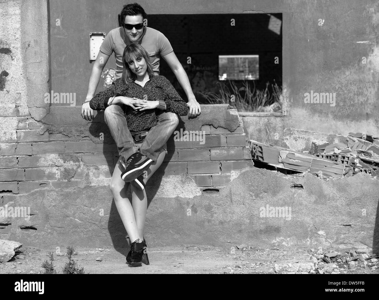 A young couple outside an industrial building ruin Stock Photo