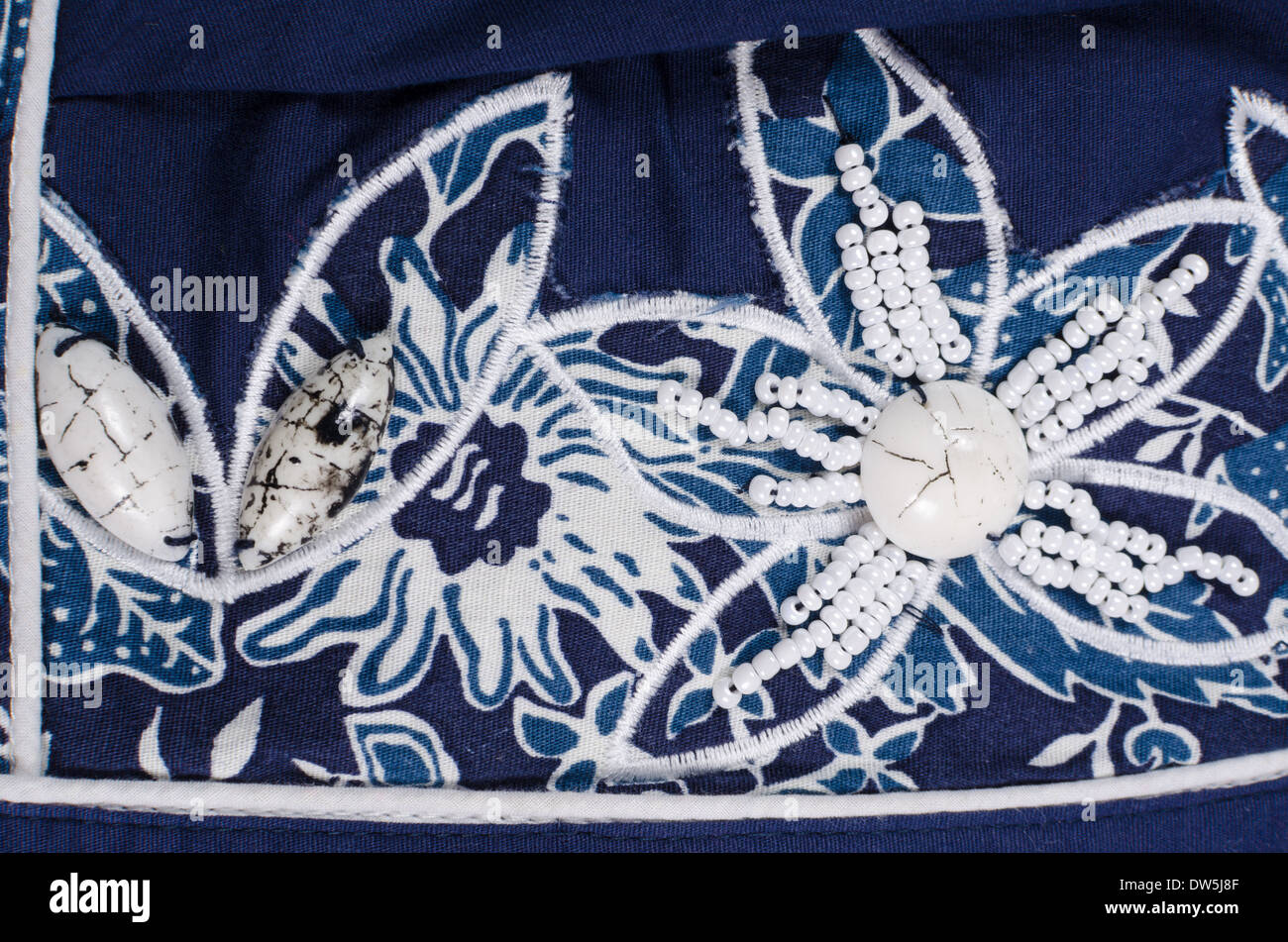 Embroidered flower shaped bead pattern on blue fabric Stock Photo
