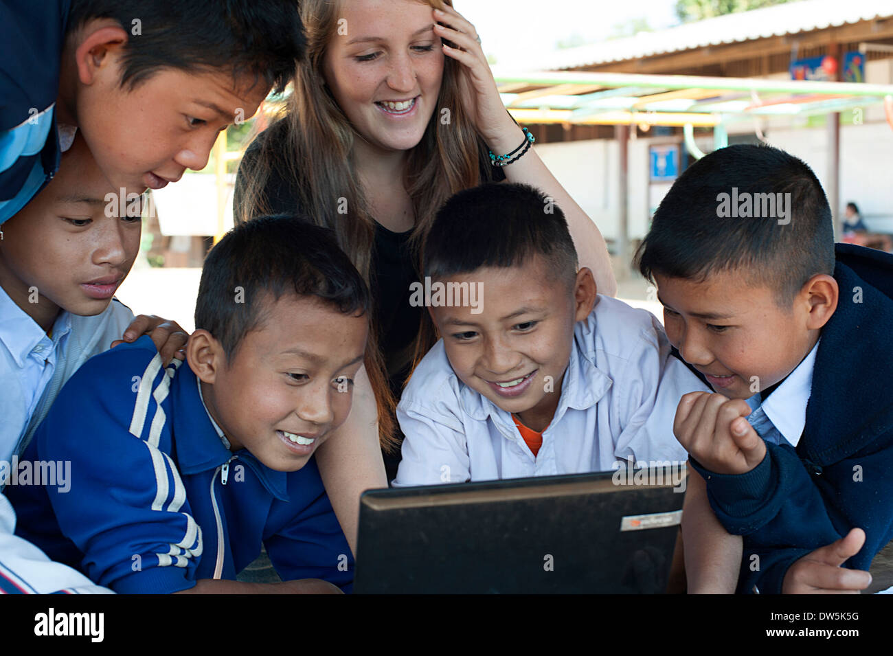 Teacher working with group of schoolboys on the computer in Huay Pakoot ...