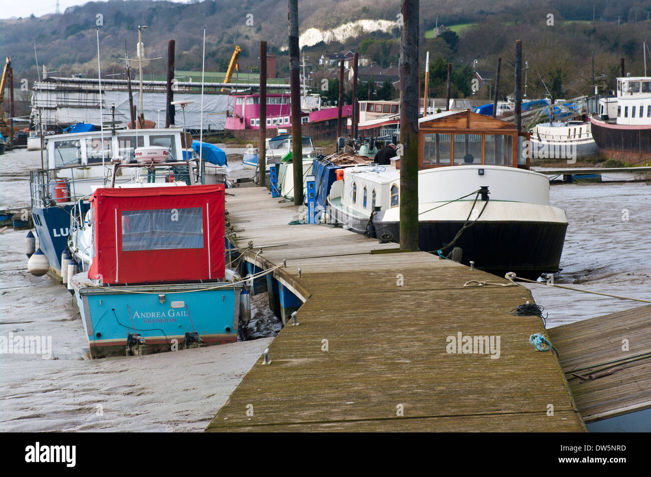 Boats Moored On Wooden Pontoons at The Port Medway Marina in Cuxton Kent England at Low Tide on the mud Stock Photo