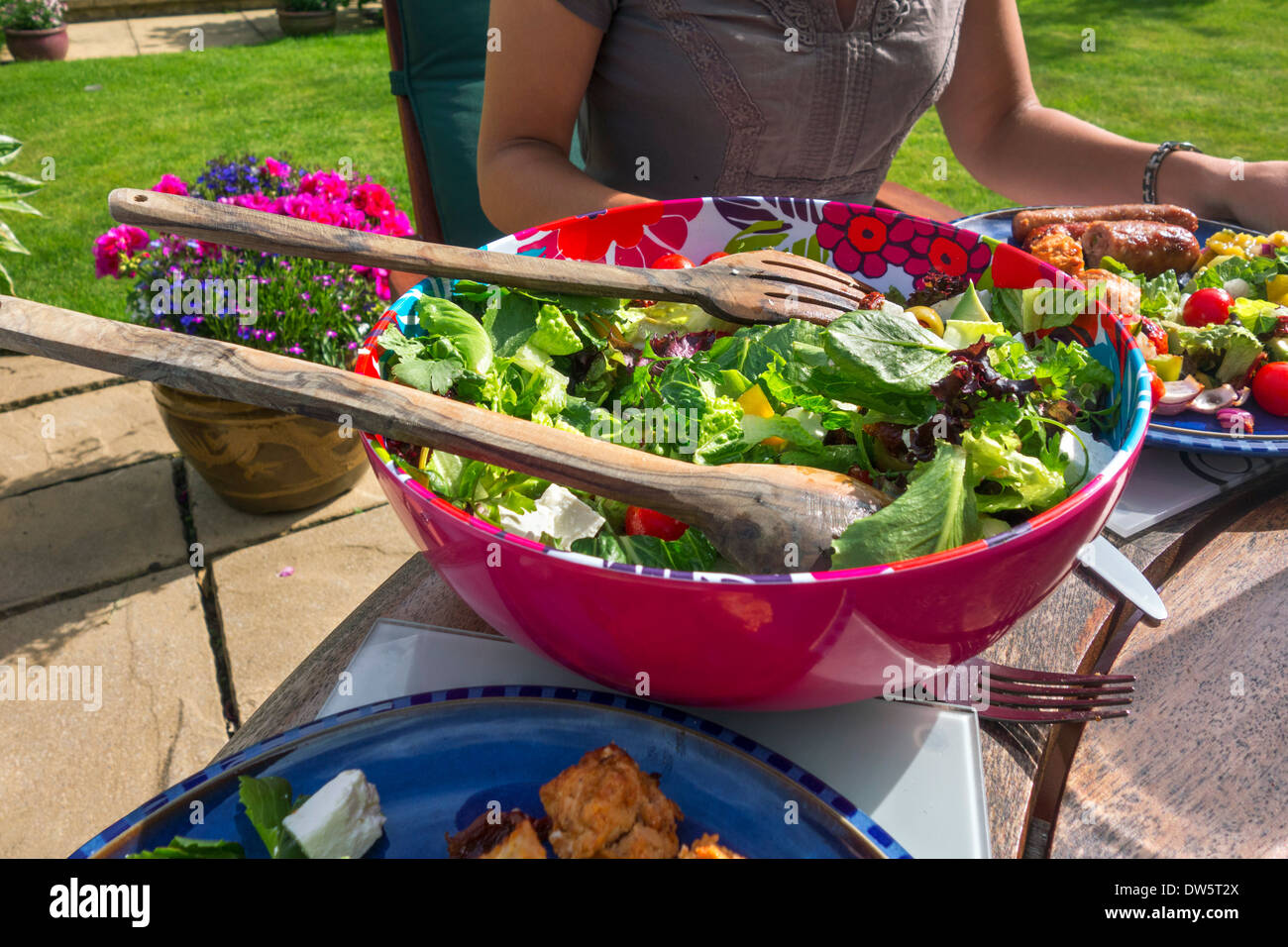 Summer barbeque around a table in an English country garden, West Yorkshire, England, UK, Stock Photo