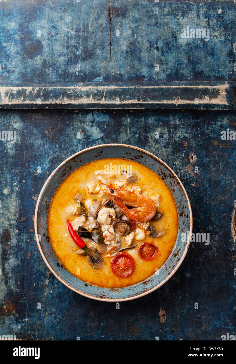 Spicy Thai soup Tom Yam with Coconut milk, Chili pepper and Seafood on