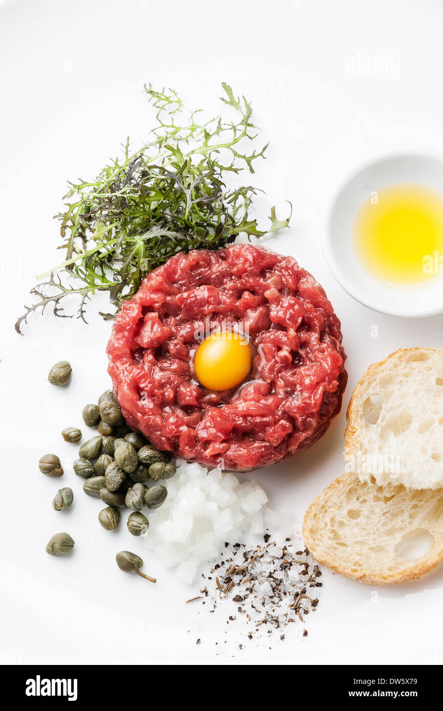 Beef tartare with capers and fresh onions on white background Stock Photo