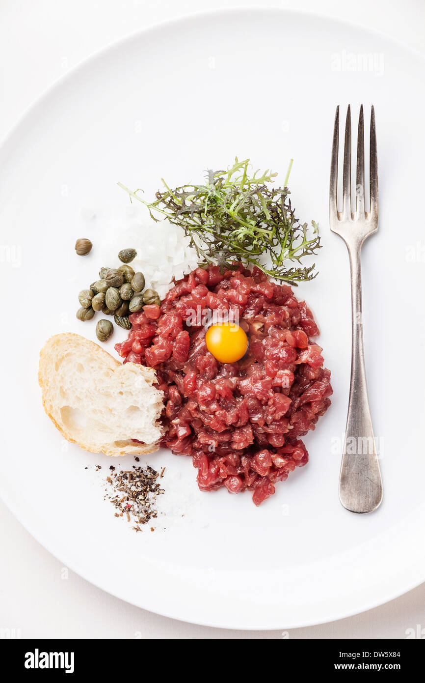 Beef tartare with capers and fresh onions on white background Stock Photo