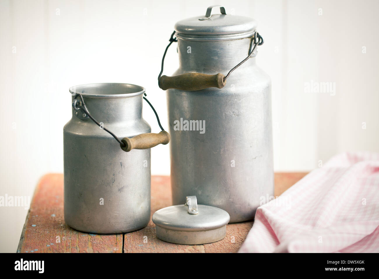 vintage milk cans on old wooden table Stock Photo