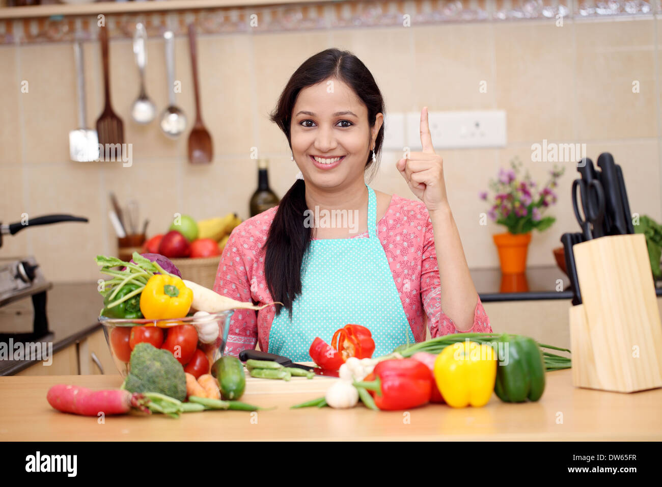 Smiling young Indian woman cutting vegetables Stock Photo Alamy