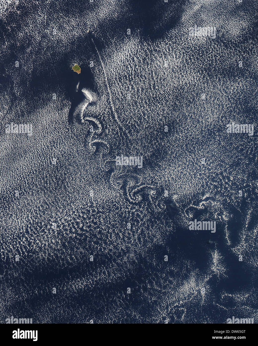 Spiral eddies known as von Kármán vortices, form in clouds downwind of Isla Socorro, a volcanic island in the Pacific Ocean. Stock Photo