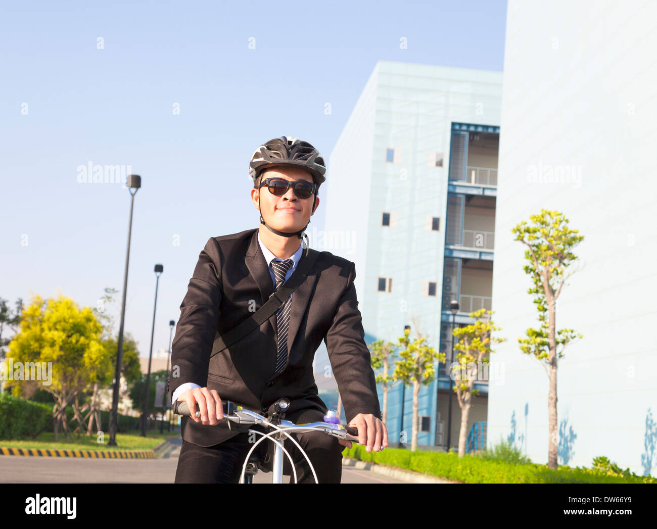 asian businessman riding a bicycle to workplace for protecting environment Stock Photo