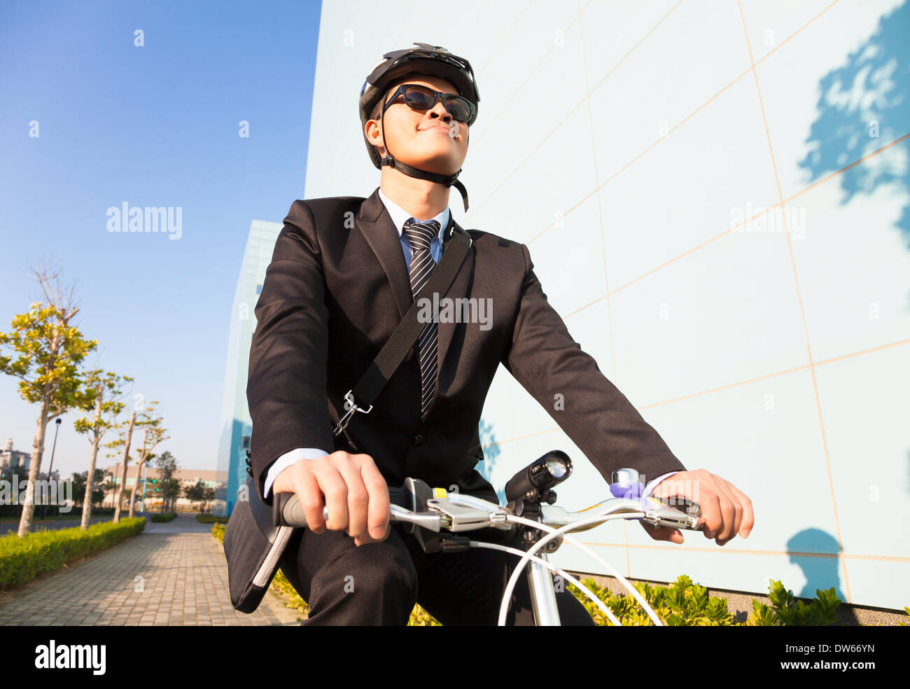 asian businessman riding a bicycle to workplace for protecting environment Stock Photo