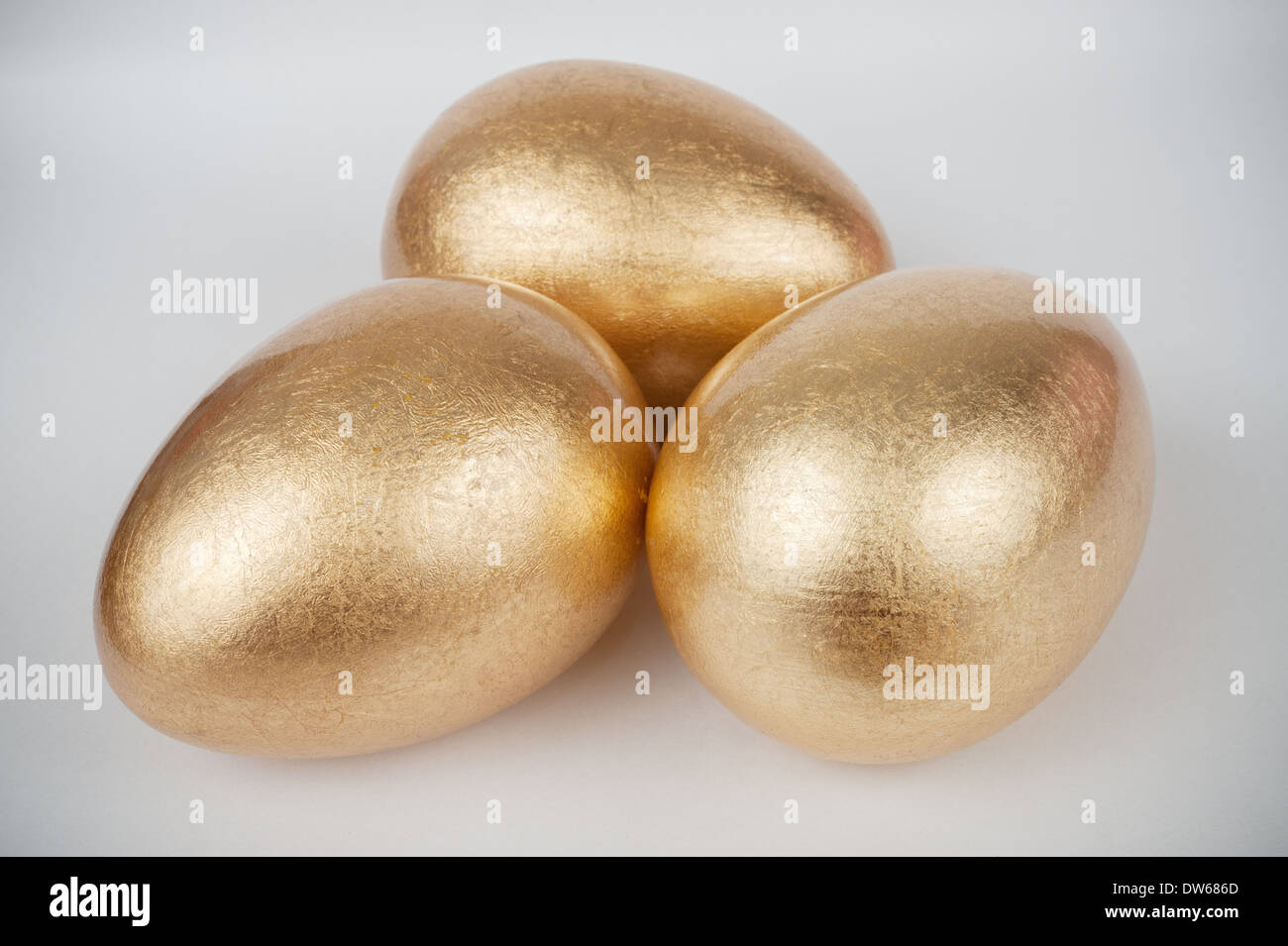 Three golden eggs on white background Stock Photo