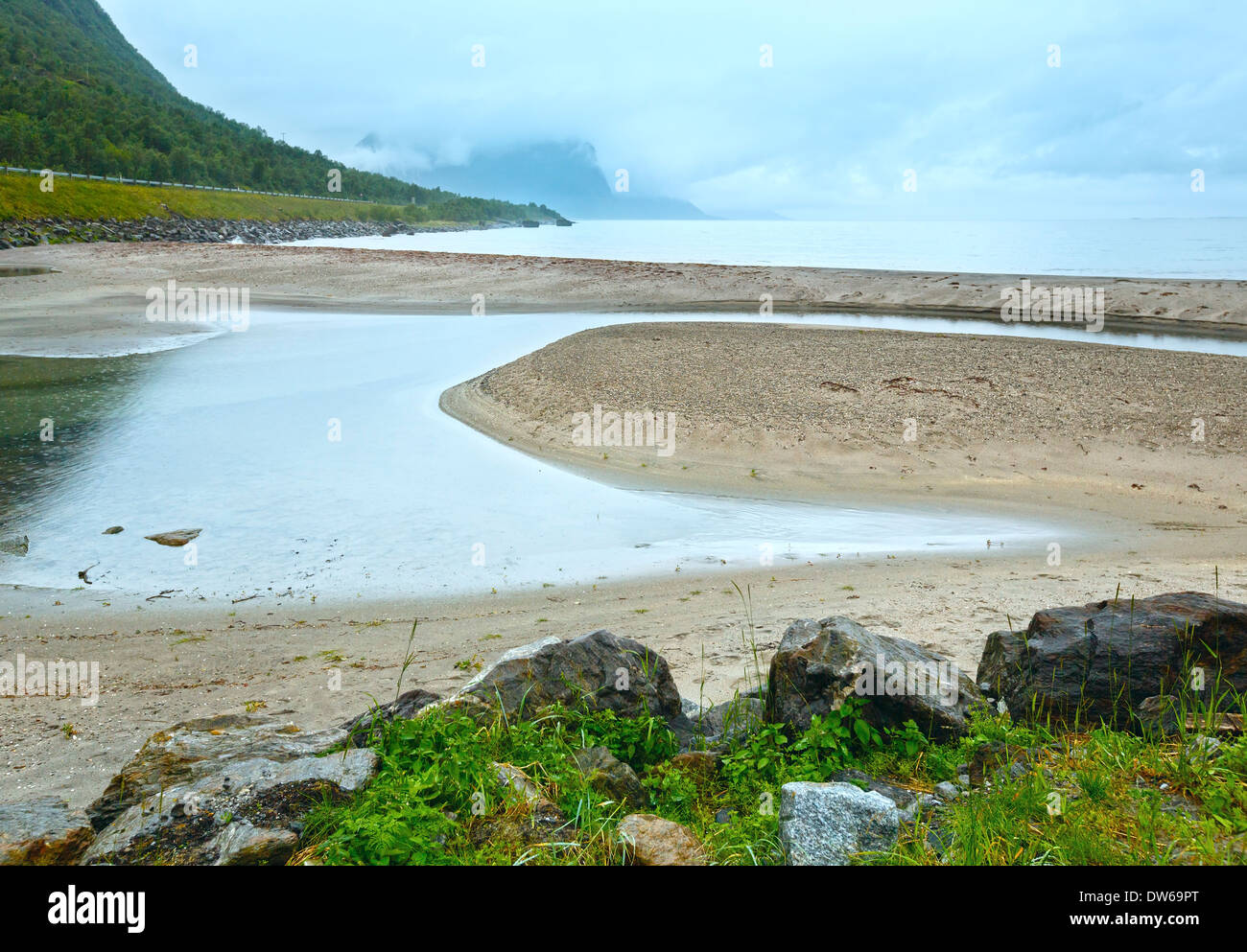 Norwegian Sea cloudy morning view with stone on beach. Stock Photo