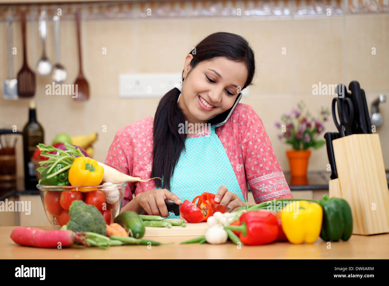 Young Indian woman working with tablet and talking on cellphone Stock Photo