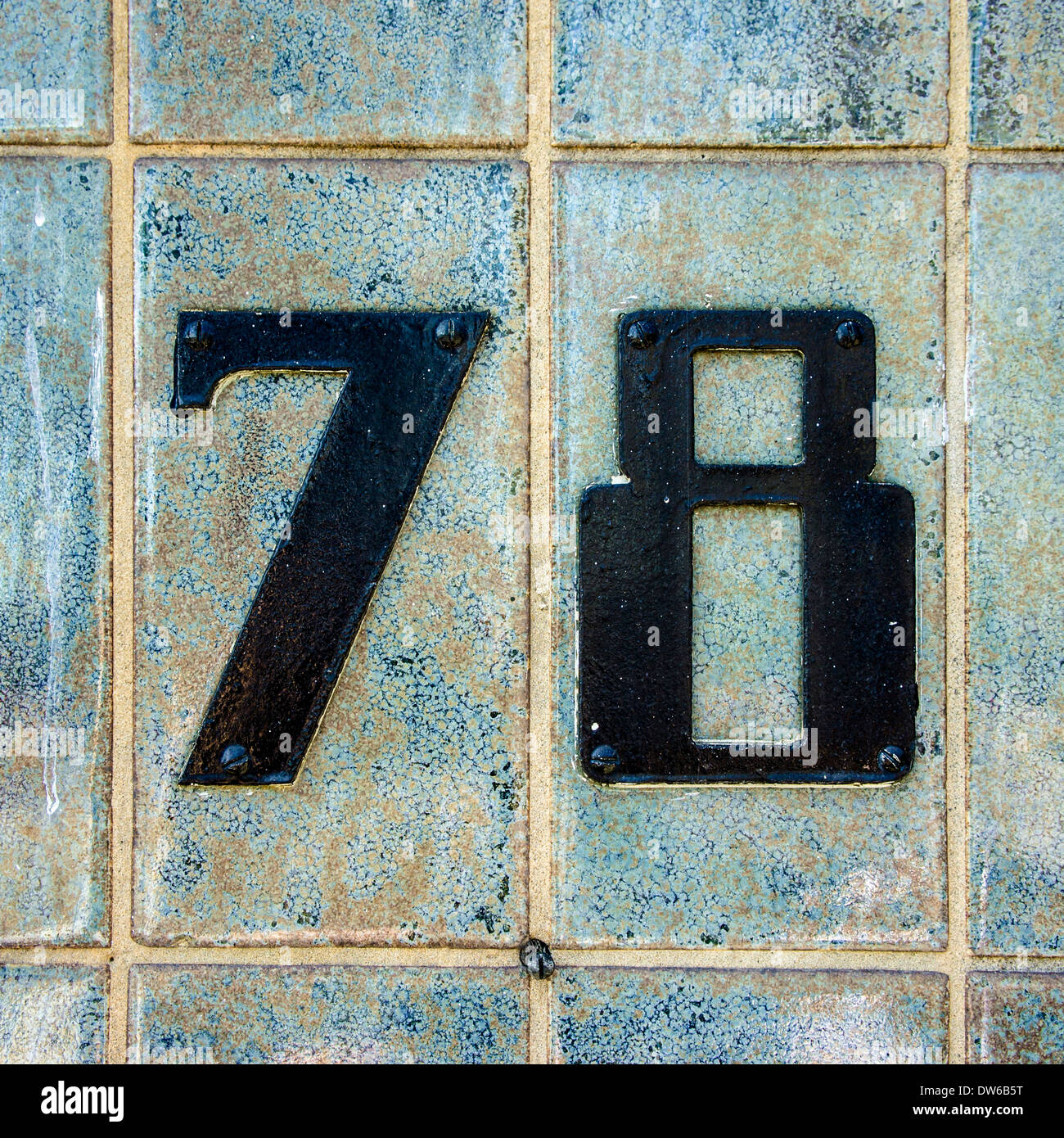 black house number seventy-eight on a wall of ceramic tiles Stock Photo