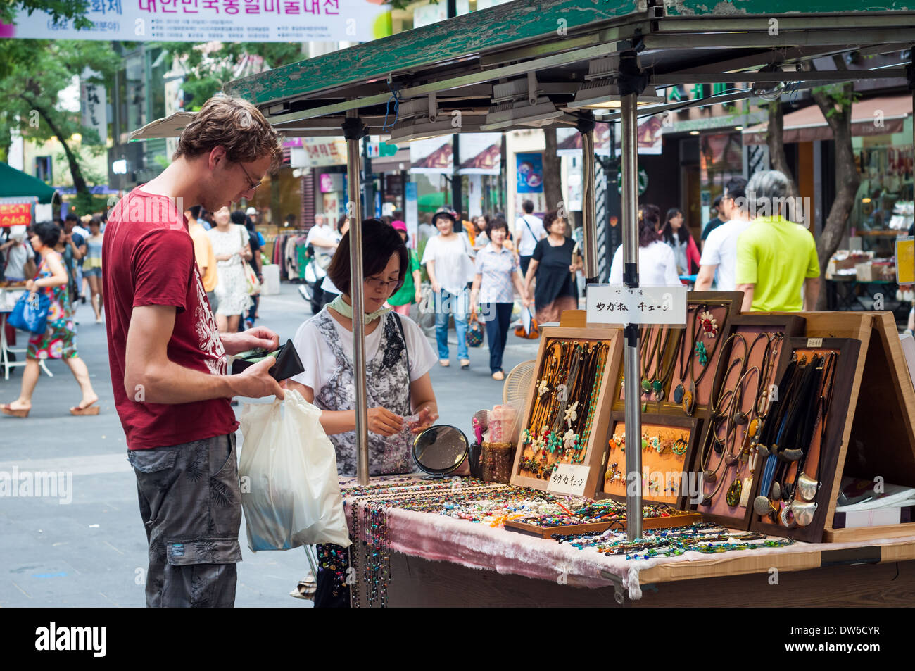 A tourist pays for some jewelry at a street vendor in Insadong, Seoul. Stock Photo