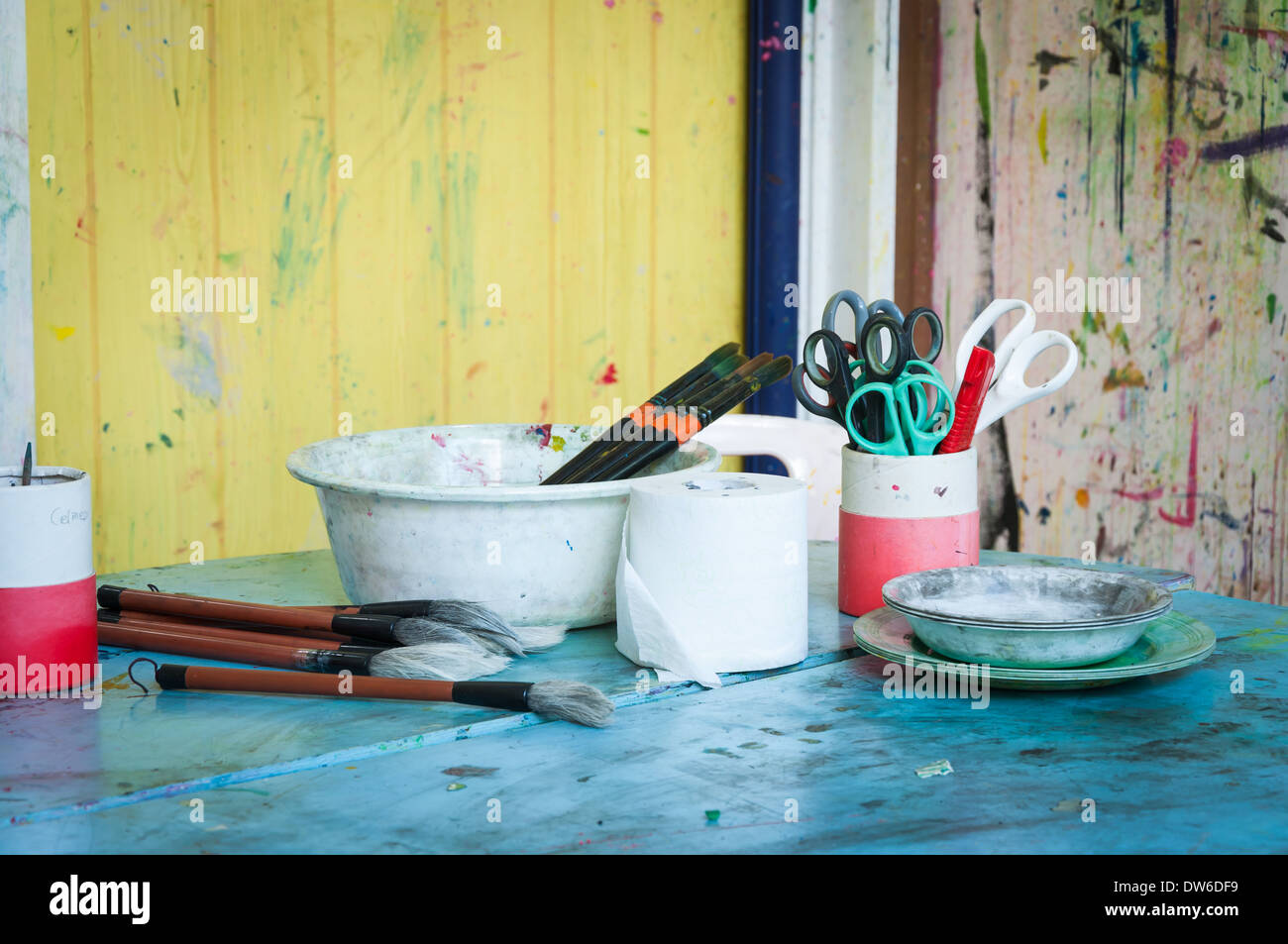 Art supplies on a table in a classroom. Stock Photo