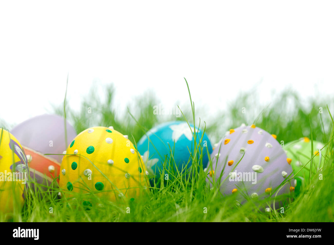 Easter eggs in fresh green grass isolated on white Stock Photo - Alamy