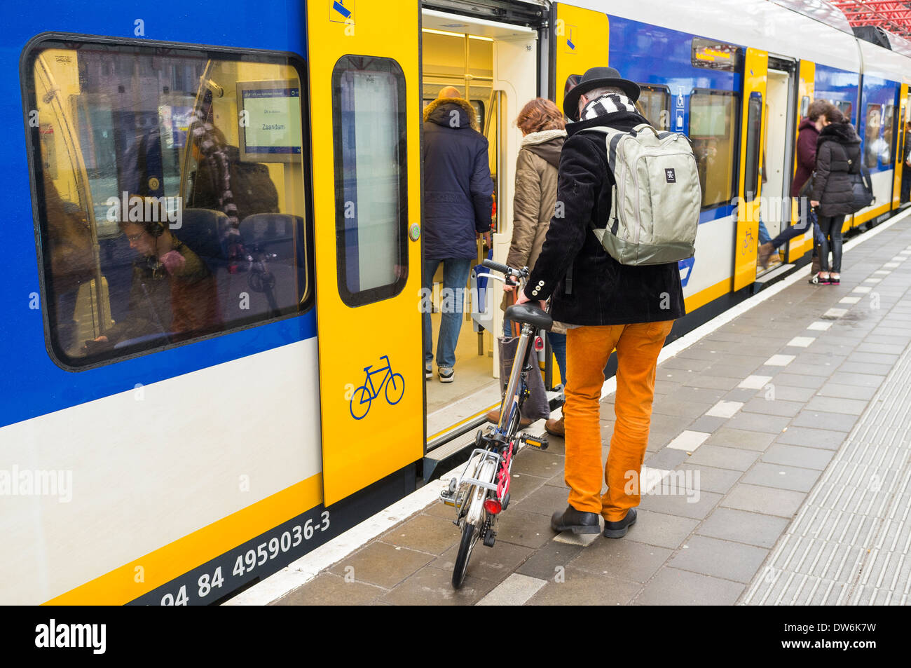 Man taking his bicycle onto the sprinter train at Zandaam railway station, Amsterdam, Netherlands. Stock Photo
