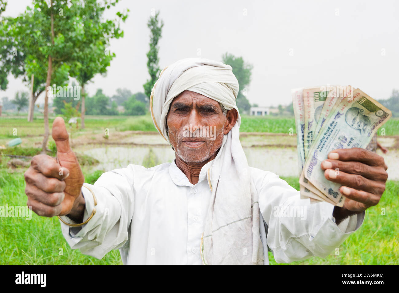 1 Indian farmer standing and showing rupees Stock Photo - Alamy