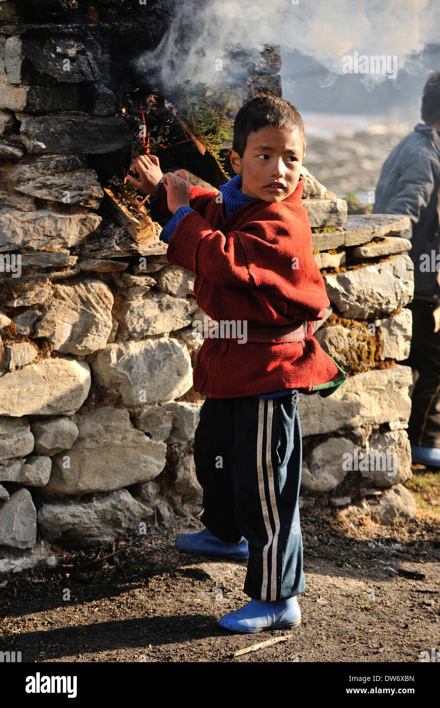 Children playing around incense burner, village of Merak, Eastern