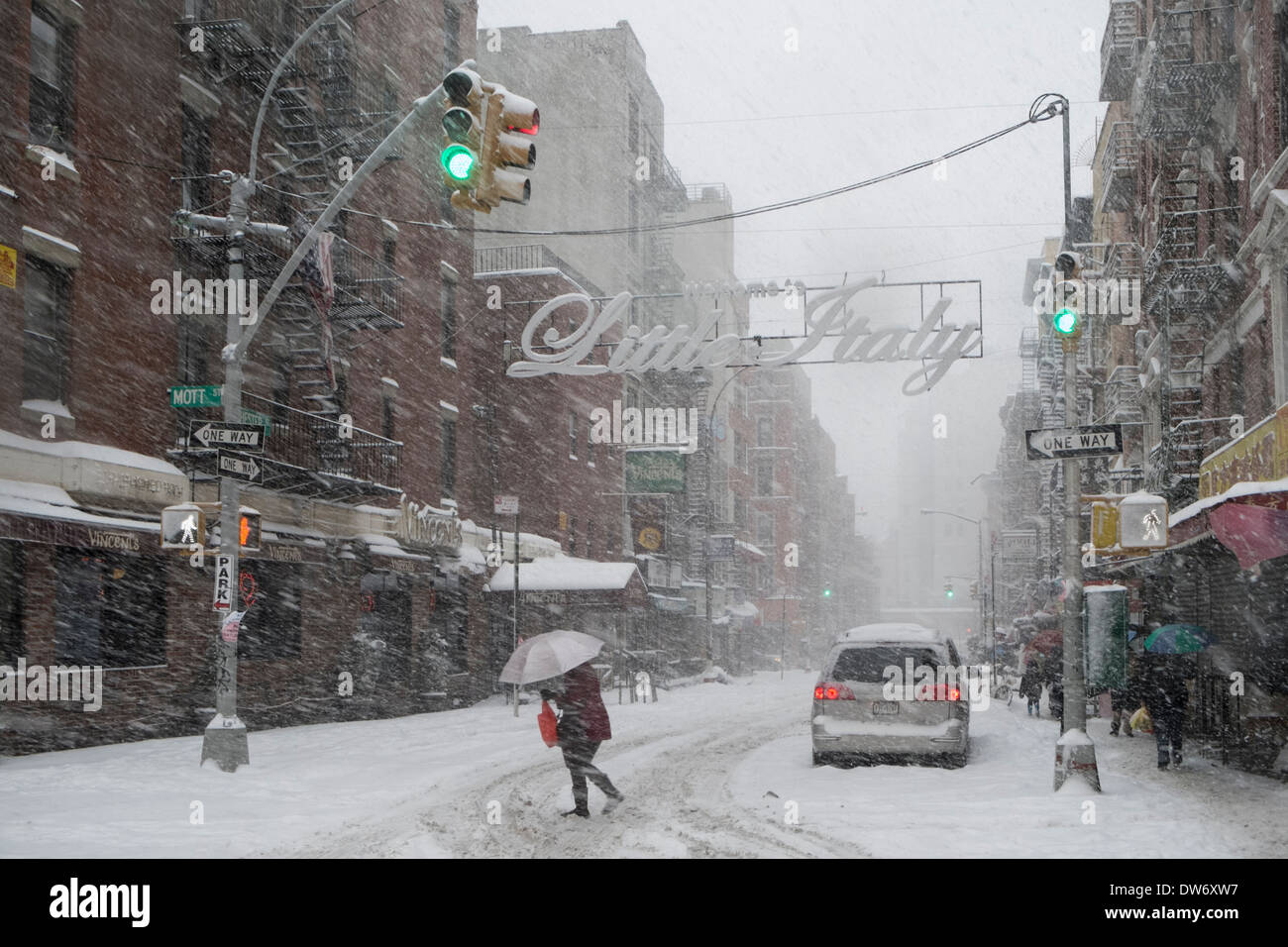 Pedestrian crossing Hester Street at Mott Street in Little Italy New York City during snowstorm Stock Photo