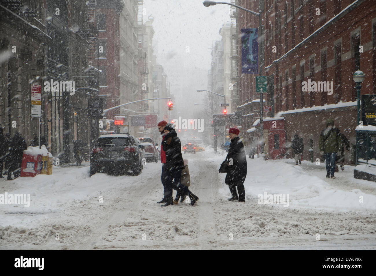 People crossing Prince Street at Broadway during snowstorm in New York City Stock Photo