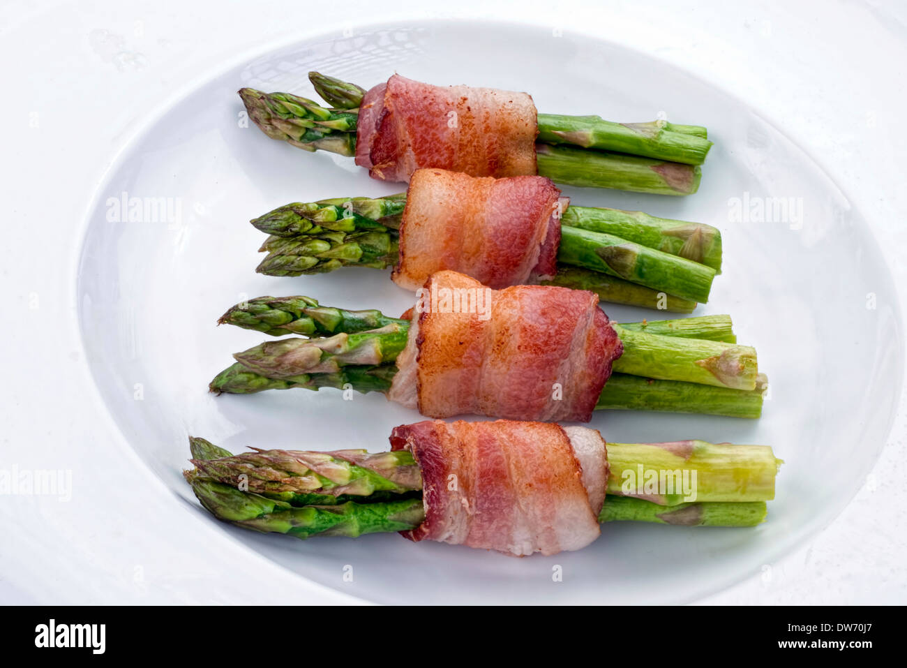 Fresh asparagus wrapped in thick bacon. Stock Photo