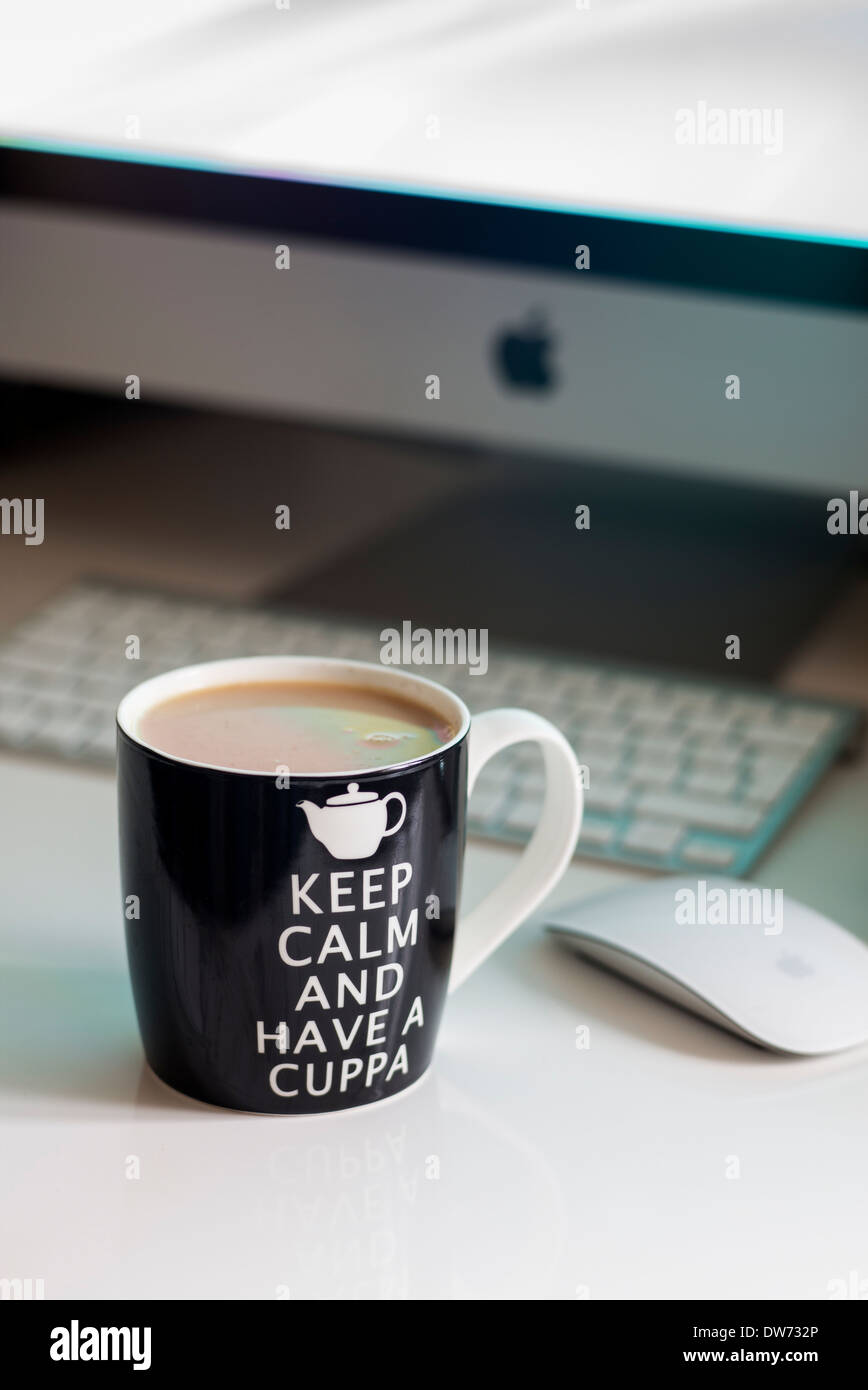 Keep calm and have a cuppa tea on a computer desk Stock Photo