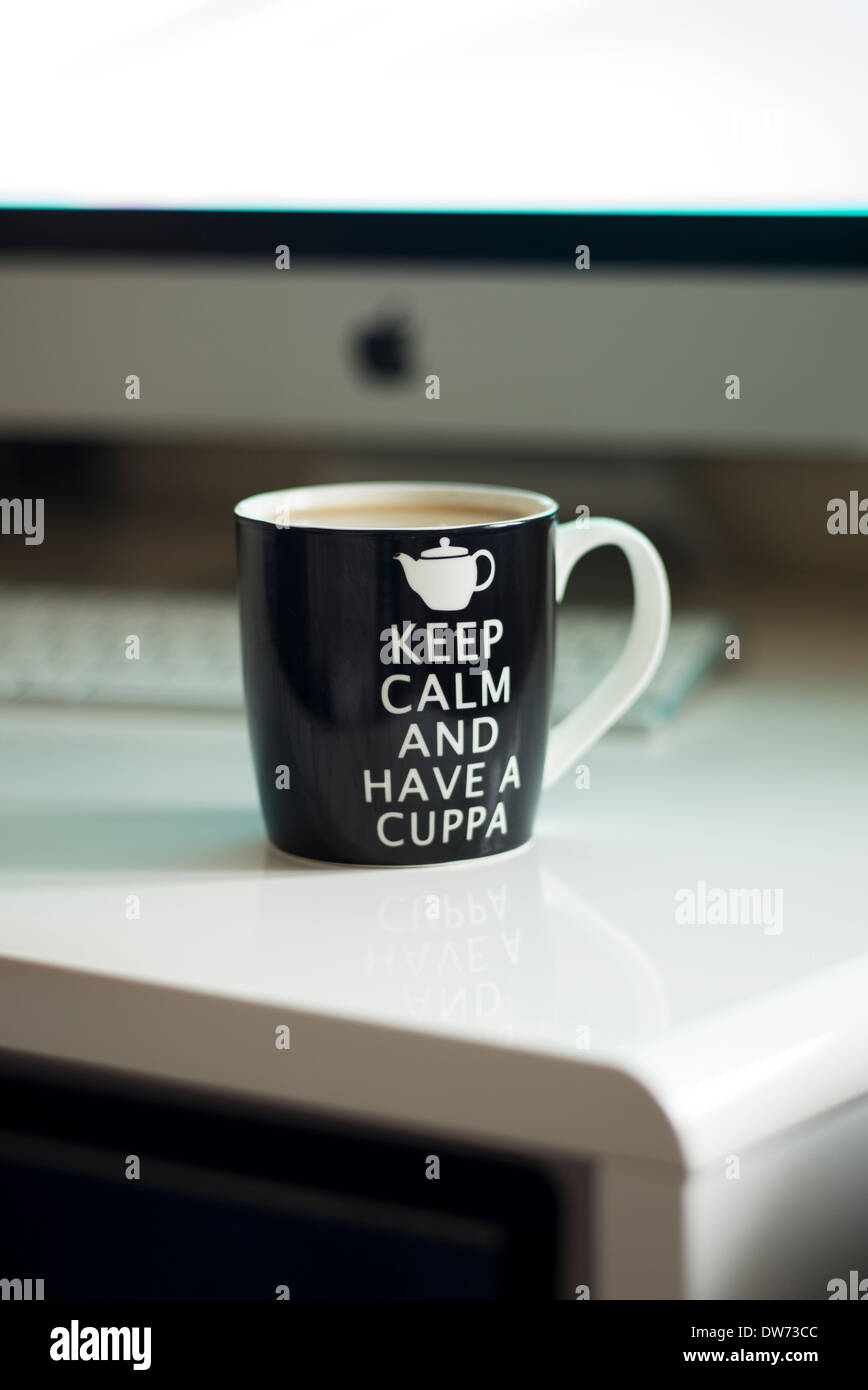 Keep calm and have a cuppa tea on a computer desk Stock Photo
