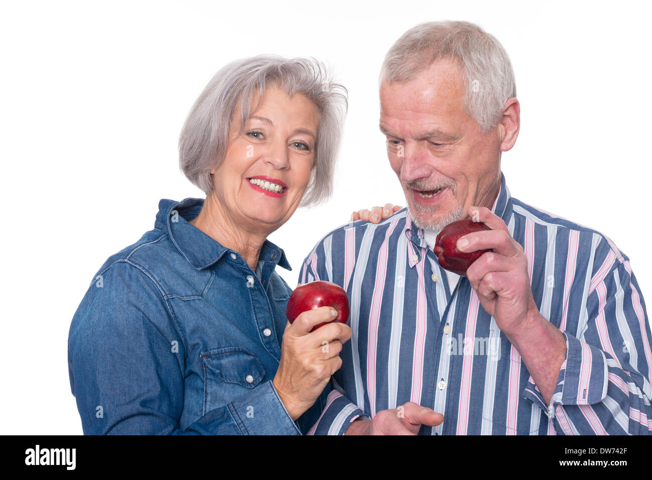 Senior couple with apple in front of white background Stock Photo