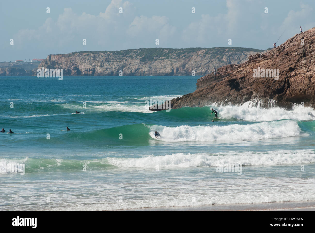 Surfers enjoy the waves at Praia do Zavial on the south coast of Portugal's Algarve region. Stock Photo