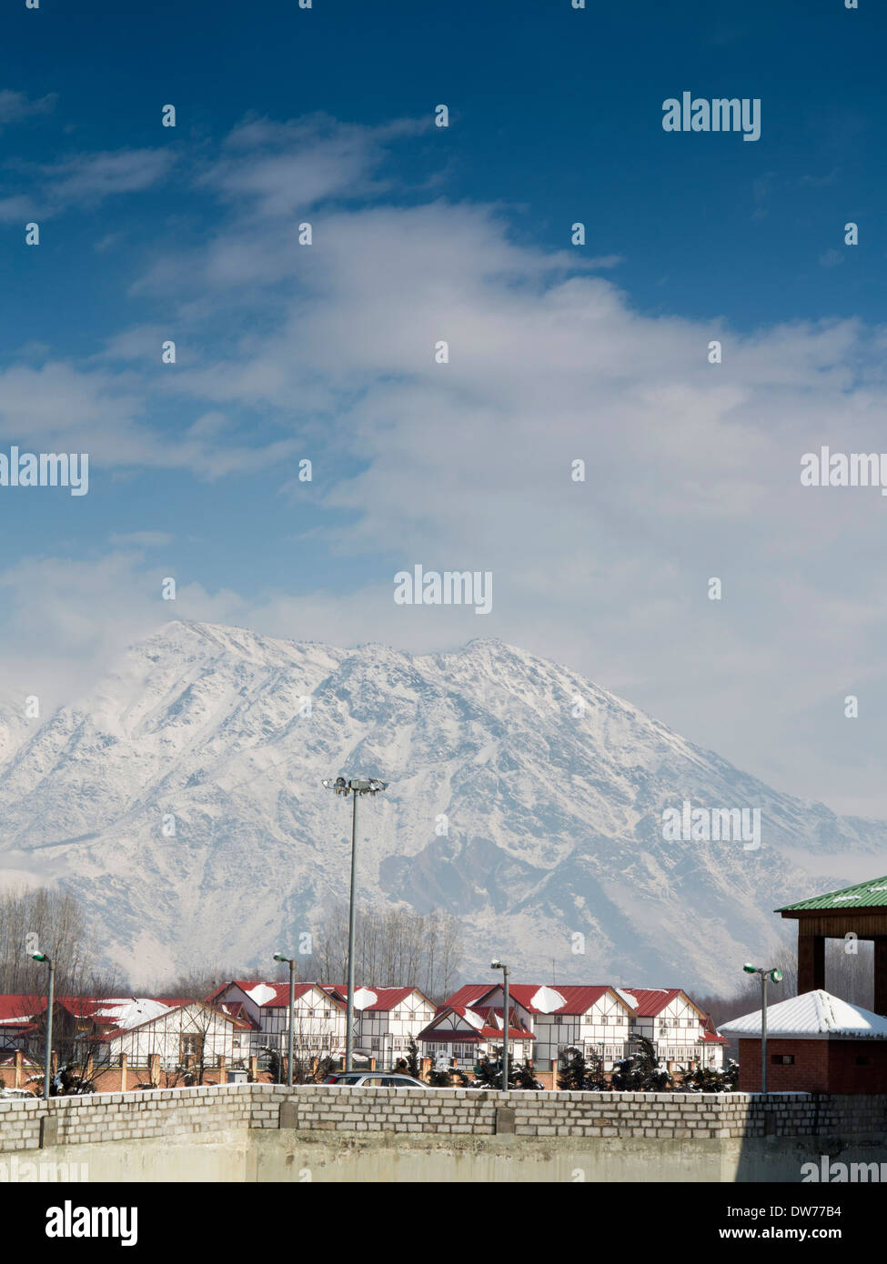 India, Kashmir, Nowgam, Srinagar Railway station, newly built housing below snow clad mountain Stock Photo