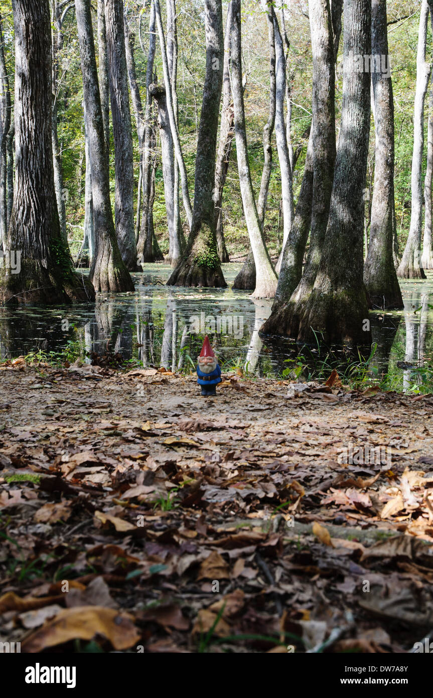 Small garden gnome standing near a cypress swamp along the Natchez Trace in Mississippi Stock Photo