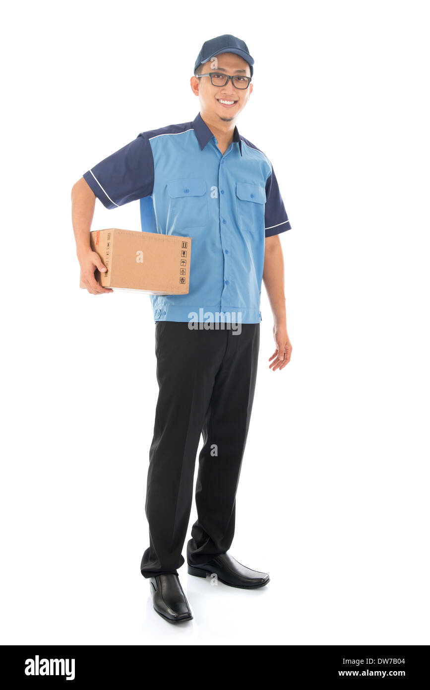 Delivery person delivering package smiling happy in blue uniform. Handsome Asian man courier full length isolated on white background. Stock Photo