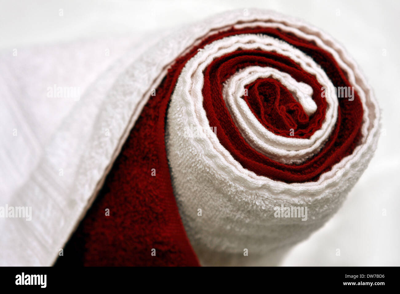 warm, dry, rolled up red and white towels in a spa Stock Photo