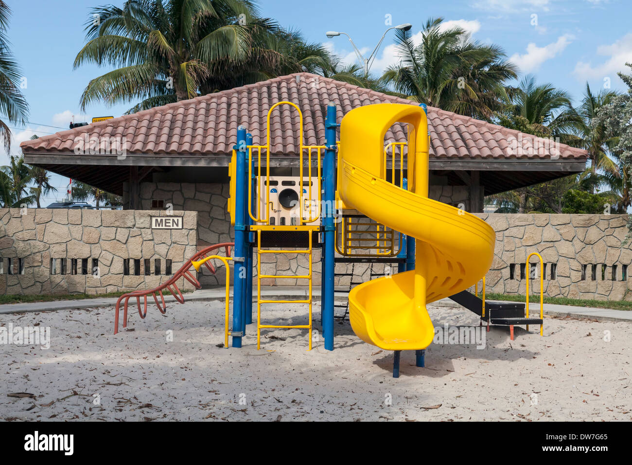 Jungle gym with yellow spiral slide in public playground in the
