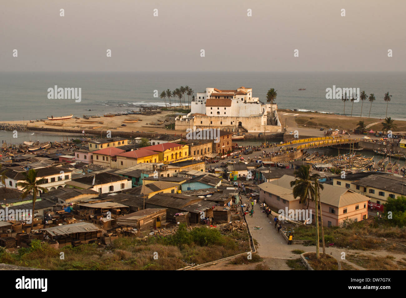 Elmina Castle and fishing village at sunset in Elmina, Cape Coast, Ghana Stock Photo