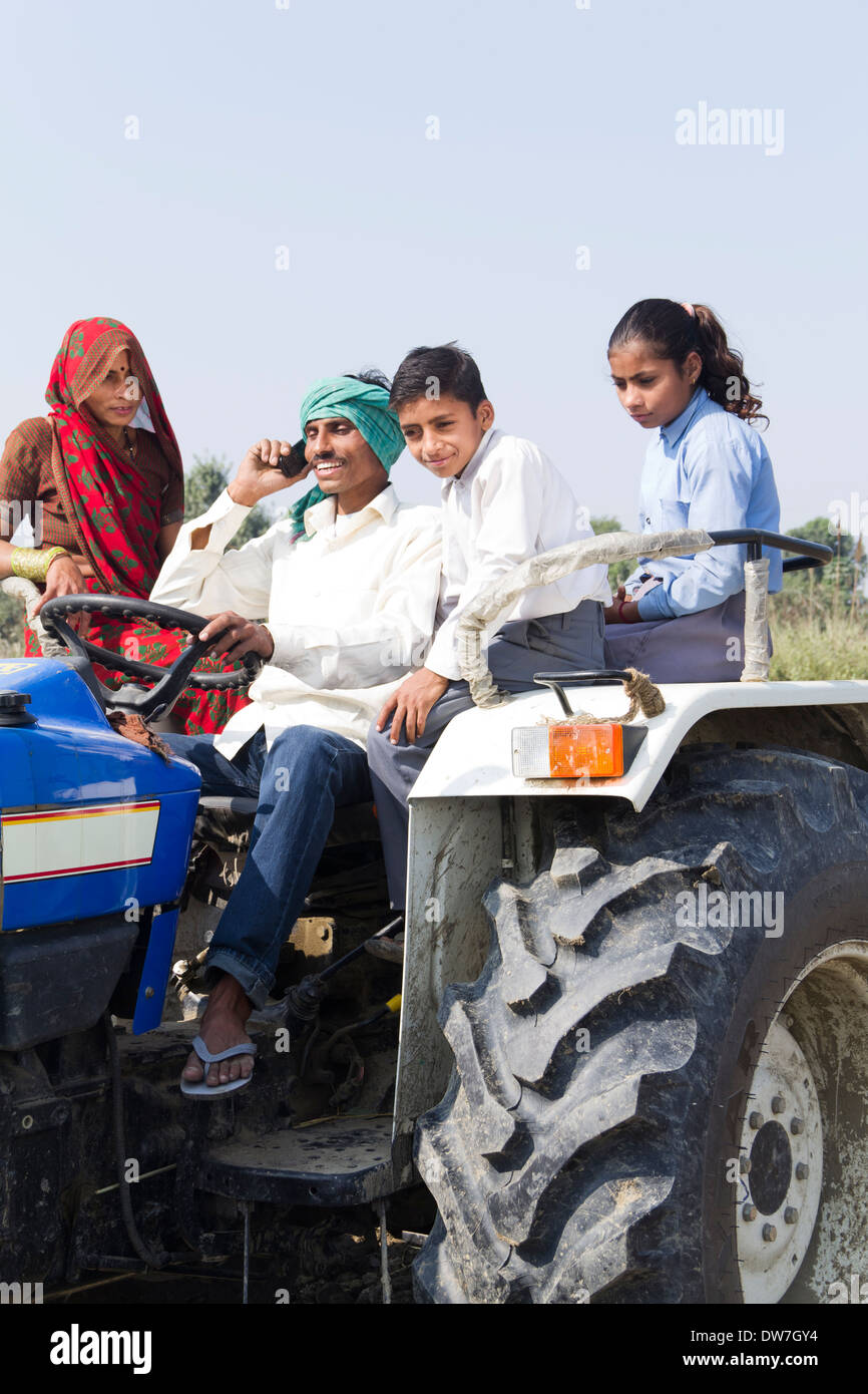 indian farmer driving tractor with family and talking with mobile Stock ...