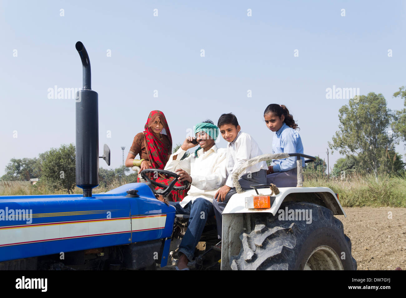 indian farmer driving tractor with family and talking with mobile Stock ...