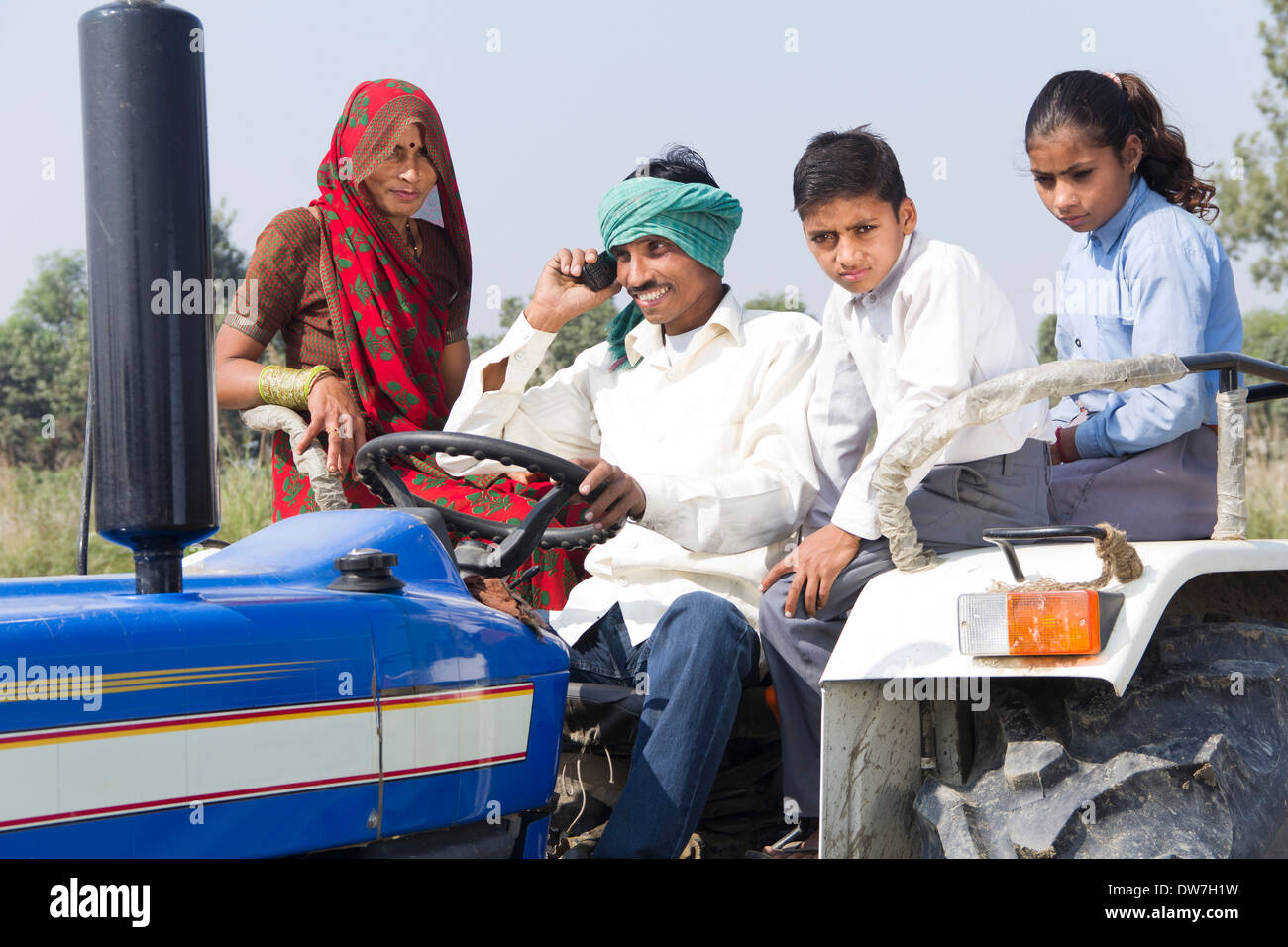 indian farmer driving tractor with family and talking with mobile Stock ...
