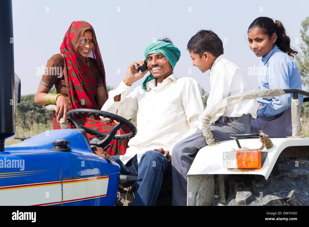 indian farmer driving tractor with family and talking with mobile Stock ...