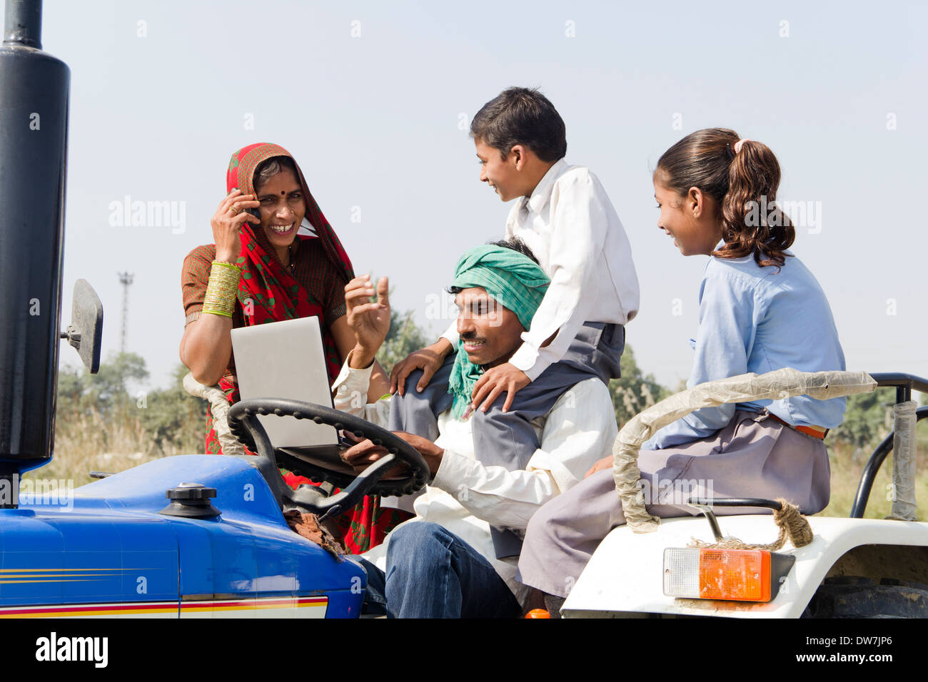 Indian farmer driving tractor with family and woman talking Stock Photo ...