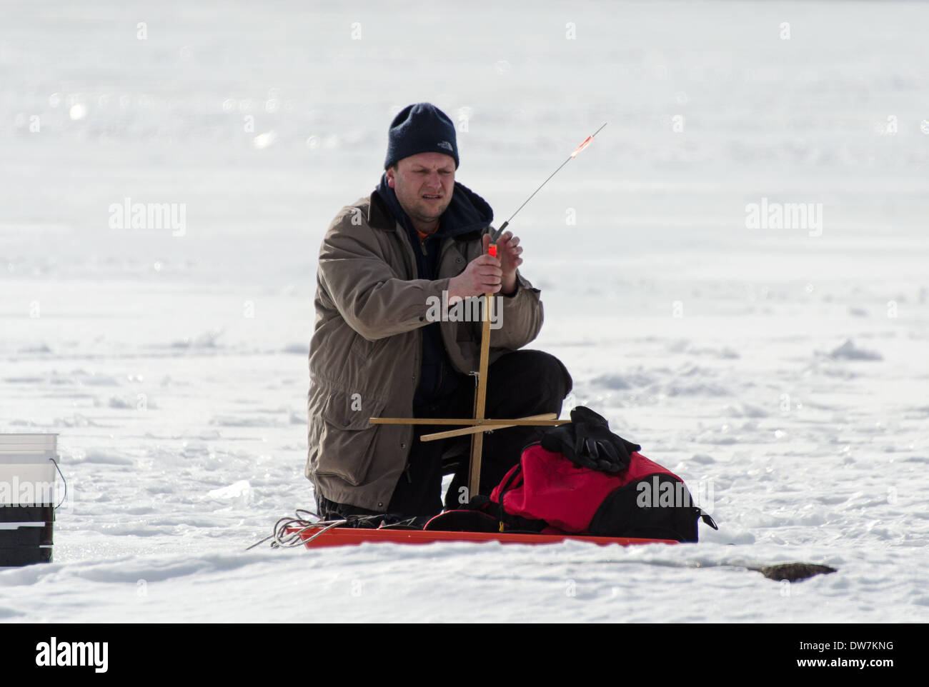 Man setting up ice fishing gear on Eagle Lake in Acadia National Park