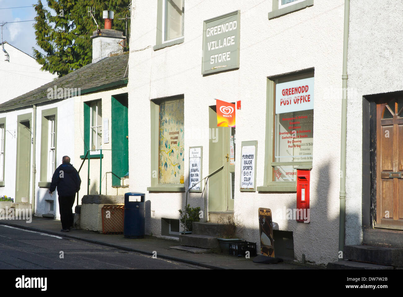 Man walking past the post office and village shop, Greenodd, South