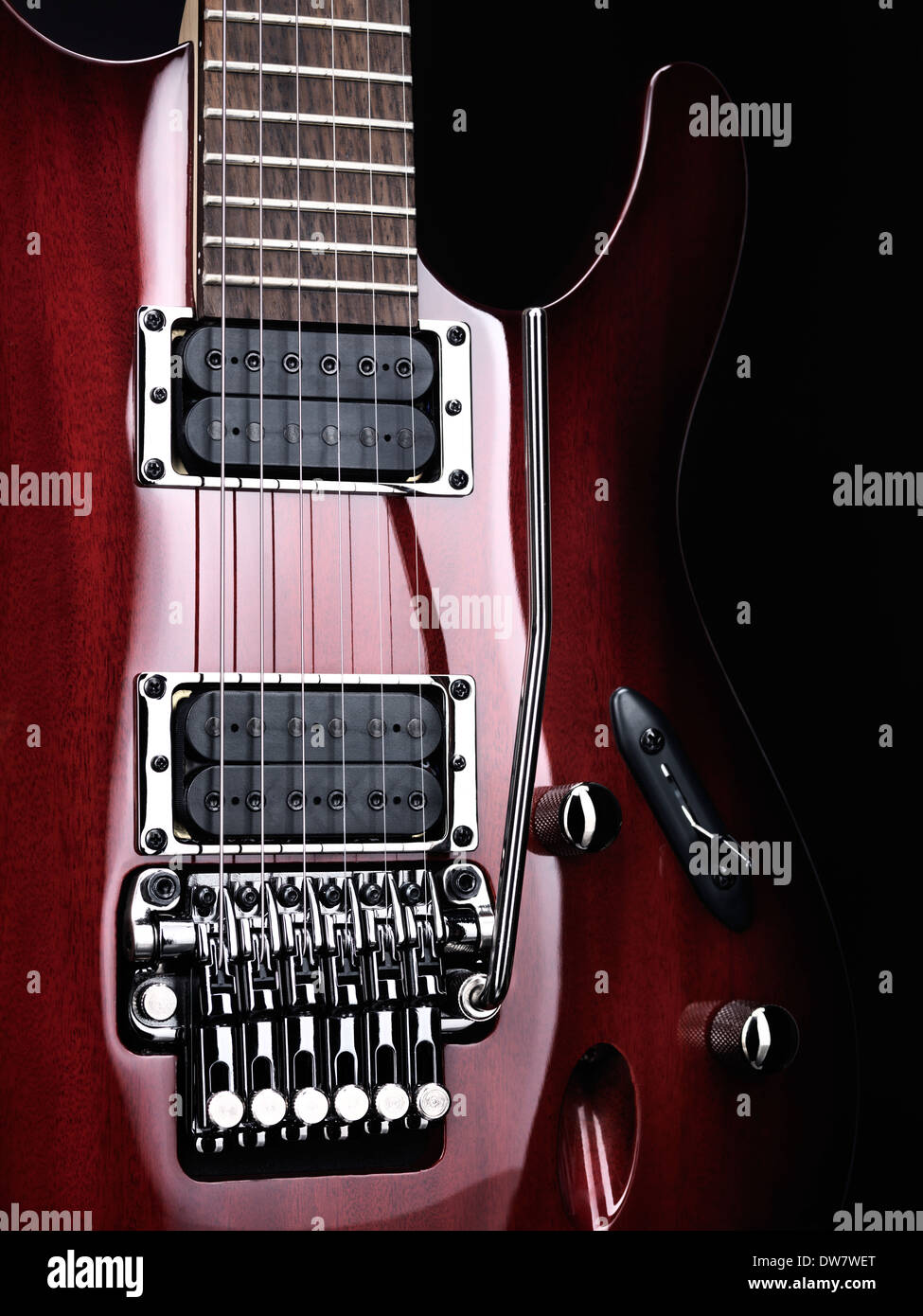 Artistic closeup of red electric guitar Ibanez with chrome parts on black background Stock Photo