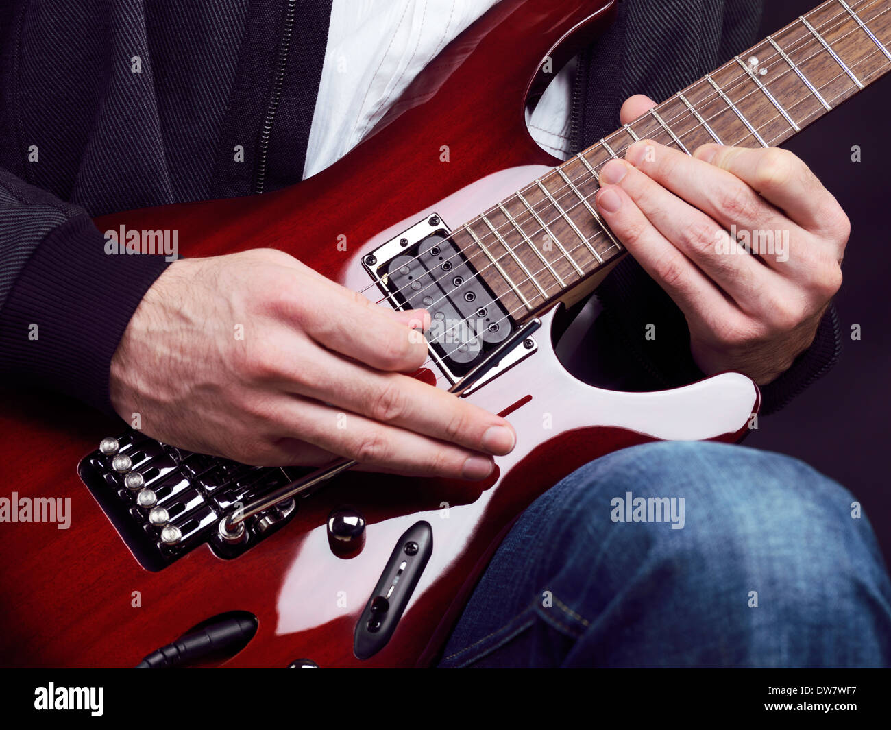 License and prints at MaximImages.com - Closeup of man hands playing red electric guitar Ibanez Stock Photo