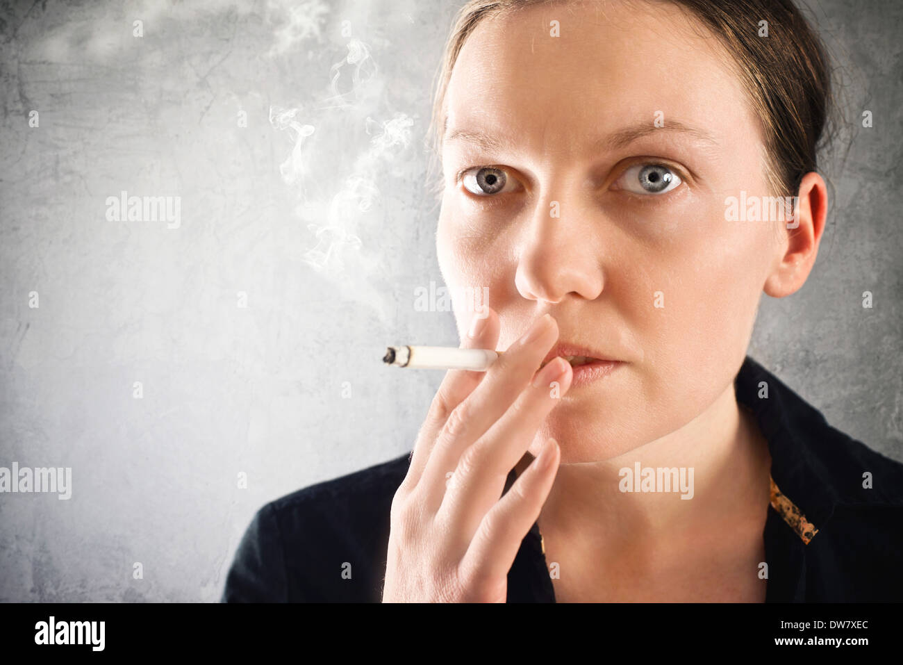 Beautiful young woman smoking cigarette, close up portrait. Stock Photo